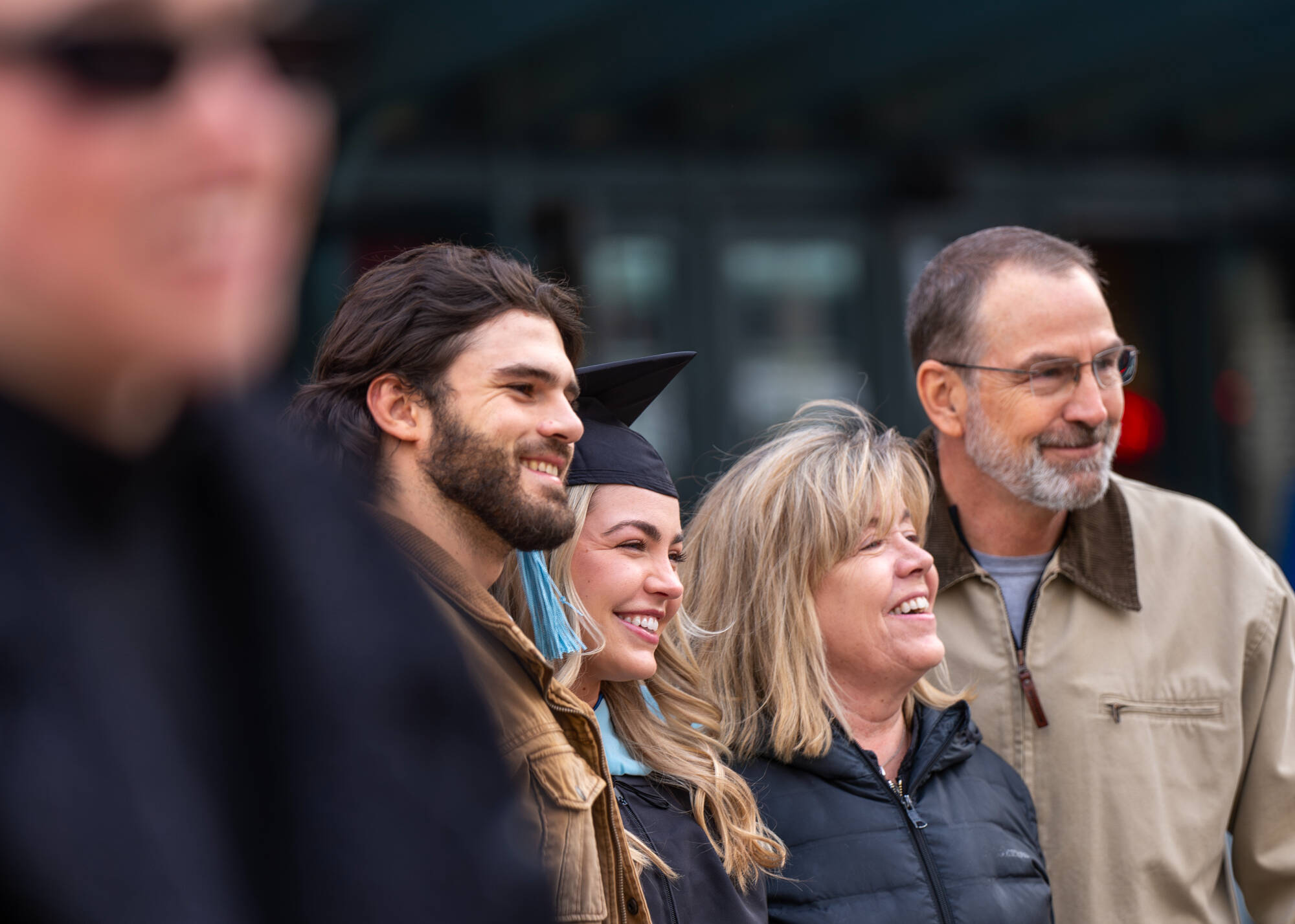 A soon-to-be graduate poses with their family before the Commencement ceremony at Van Andel Arena December 7 2024.